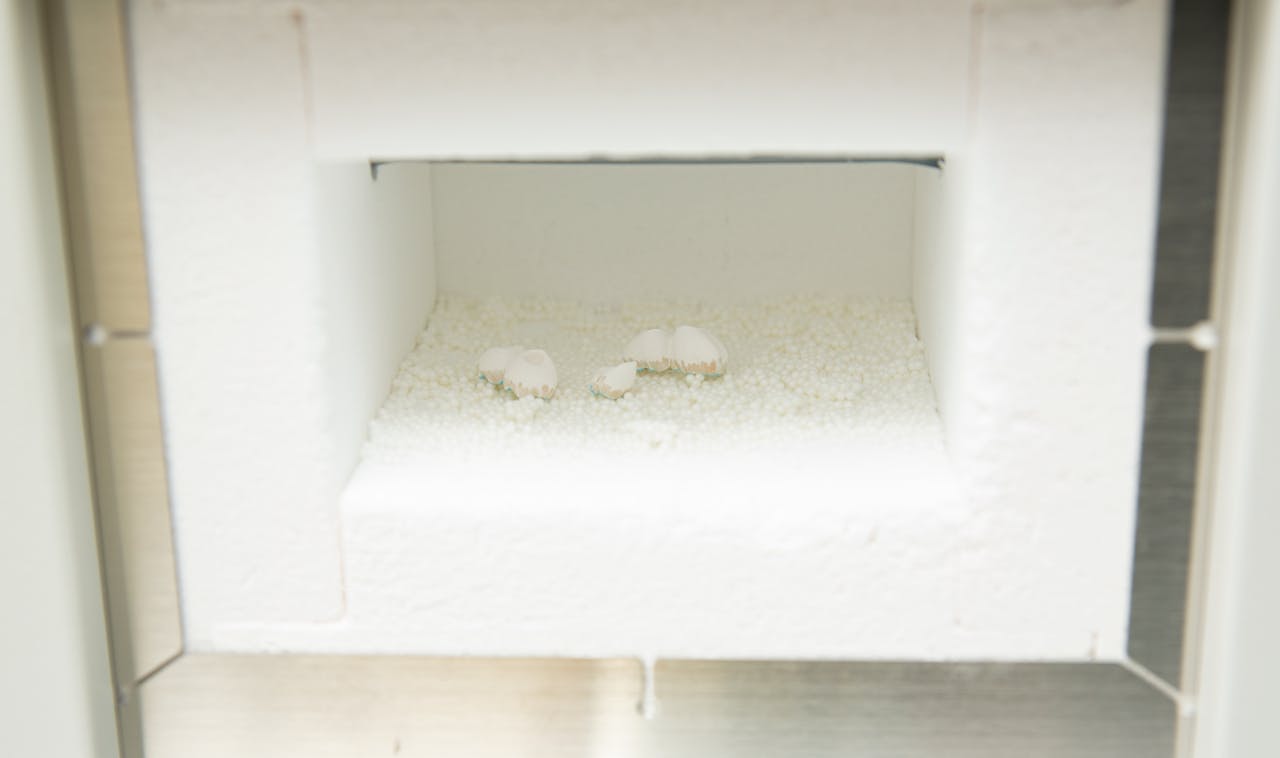Dental lab furnace with dentures inside for production of prosthetic teeth.